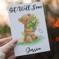 someone holding up a card with a teddy bear on it that says, get well soon