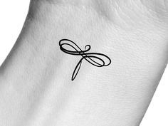 a black and white photo of a dragonfly tattoo