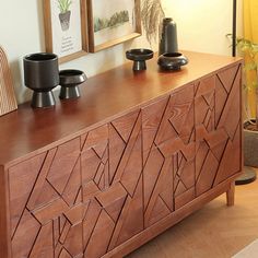 a wooden cabinet with two black vases on it