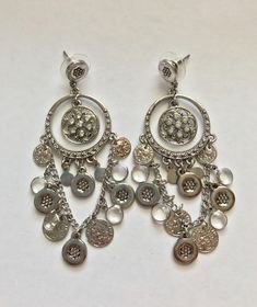 "These are a pair of silvertone coin, crystal and rhinestone dangle pierced earrings. They are R.J. Graziano. They measure 3 1/4\" long and 1 1/4\" wide. This piece is part of a large estate that was chock full of QVC and HSN jewelry that was unworn and in the original boxes. This item is in excellent preowned vintage condition. It appears to have never been worn" Silver Bling Dangle Chandelier Earrings, Silver Metal Clip-on Earrings With Rhinestones, Silver Metal Clip-on Earrings Costume Jewelry, Sparkly Metal Chandelier Drop Earrings, Bling Metal Dangle Chandelier Earrings, Metal Bling Chandelier Dangle Earrings, Bling Metal Chandelier Dangle Earrings, Silver Earrings With Dangling Charms, Solid Gold Bracelet