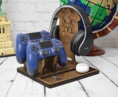 two video game controllers and headphones are on a wooden stand next to a globe