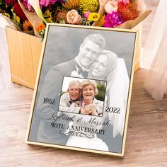 an anniversary photo frame with flowers in the background and a bouquet of flowers behind it