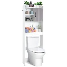 a white toilet sitting next to a tall shelf filled with towels and other items on top of it