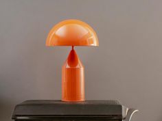 an orange lamp sitting on top of a black table