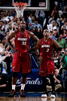 two basketball players standing next to each other in front of a crowd at a game