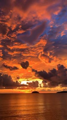 the sun is setting over the ocean with clouds in the sky and water below it