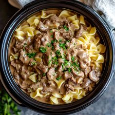 a bowl filled with meat and noodles on top of a table