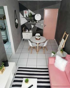 a living room filled with furniture next to a white table and black and white striped rug