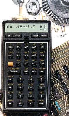 an old calculator sitting on top of electronic components