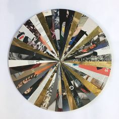 a clock made out of different types of papers on a white surface with the number six in the center