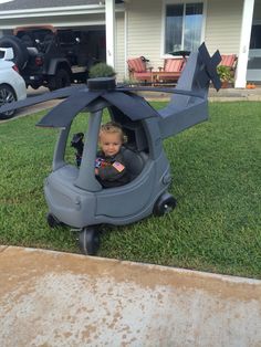 a small child sitting in a toy helicopter