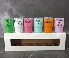 the bride and groom tumblers are lined up in a row on top of a white box