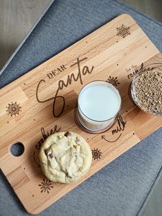 a wooden cutting board topped with cookies and milk