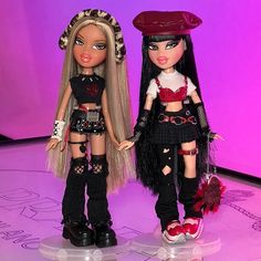 two dolls are standing next to each other