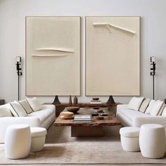 a living room filled with white furniture and art