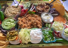 a platter filled with lots of different types of food and dips on top of it