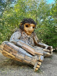 a wooden sculpture sitting on top of a pile of logs