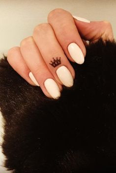 a woman's hand with a crown tattoo on it