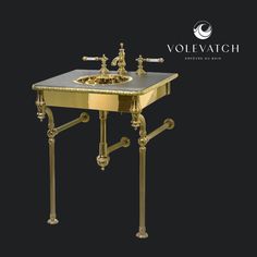 a gold sink with two faucets on it and the word vollevich above it