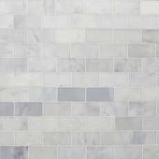 a white marble tile wall with grey and gray tiles on the bottom, in an angled pattern