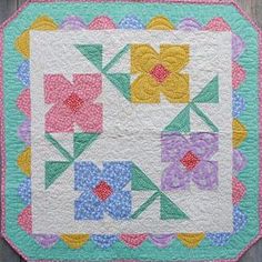 a quilted table topper with flowers on it