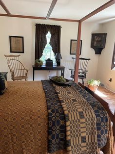 a bed in a bedroom next to two chairs and a table with a tray on it