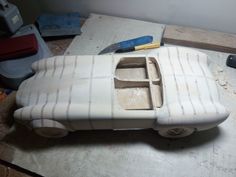 a car made out of clay sitting on top of a table next to a pair of scissors