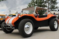 an orange and white buggy is parked on the street