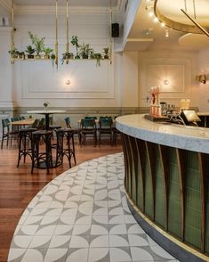 the interior of a restaurant with tables, chairs and potted plants hanging from the ceiling