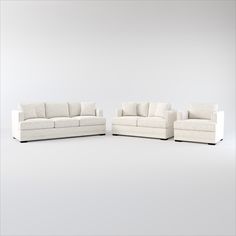 three white couches sitting next to each other on top of a gray flooring