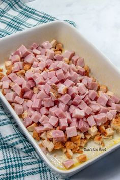 a pan filled with ham on top of a blue and white towel