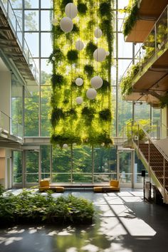 an indoor space with plants growing on the wall and hanging from the ceiling, in front of large windows