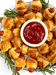 a platter filled with pigs in a blanket and ketchup