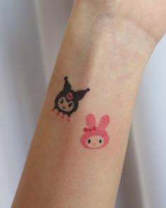 a person with a tattoo on their arm and an animal sticker on the wrist