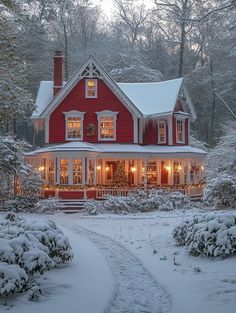 a red house is lit up with christmas lights in the front yard and snow on the ground