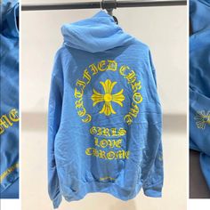 a blue hoodie with yellow lettering on the front and back, hanging from a clothes rack