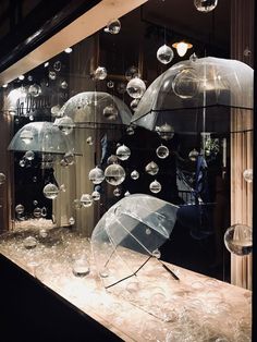 there are many clear umbrellas on display in the window