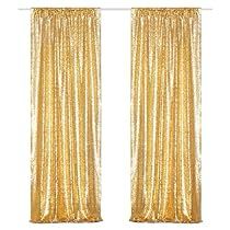 two gold curtains hanging on the side of a wall