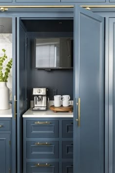 a kitchen with blue cabinets and white counter tops, gold trim on the doors is shown