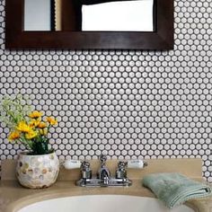 a white sink sitting under a bathroom mirror next to a wooden framed mirror above it