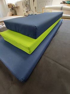 two blue and green mattresses sitting on top of each other in an office setting