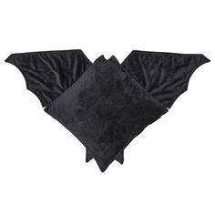 two black bat shaped pillows sitting on top of each other