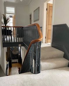 the stairs in this house are made of metal and wood, while carpet is white