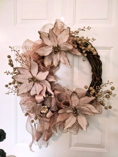 a wreath is hanging on the door with flowers and ribbons around it's edges