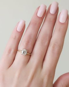 a woman's hand with a ring on her finger and a diamond in the middle