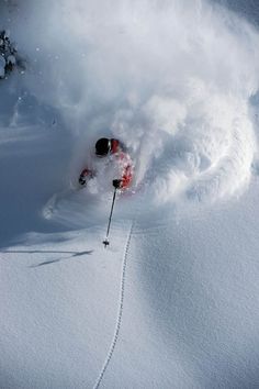 a man riding skis down the side of a snow covered slope