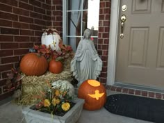 a statue and pumpkins are on the front porch