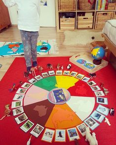 a child standing on the floor in front of a wheel of pictures and toy animals