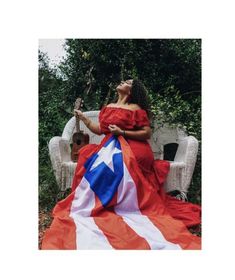 a woman in a red dress sitting on a chair with an american flag draped over her