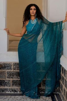 Teal blue ruffle edge saree with hand embroidered border. Paired with a padded halter neck blouse.
Components: 2
Pattern: Embroidered
Type Of Work: Hand embroidery
Neckline: Halter
Sleeve Type: Sleeveless
Fabric: Chiffon
Color: Blue
Other Details: 
Attached lining
Occasion: Puja - Aza Fashions Blue Hand Embroidery, Sleeveless Blouse Saree, Embroidery Neckline, Halter Neck Blouses, Peach Saree, Simple Saree Designs, Butterfly Net, Saree And Blouse, Scallop Border